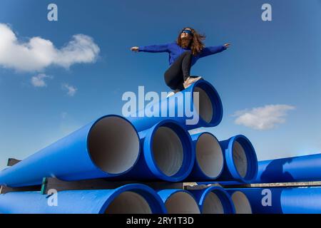 Woman in blue on blue pipes. Stock Photo