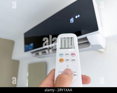 Air conditioner. Temperature adjustment by remote control at 19°C Stock Photo
