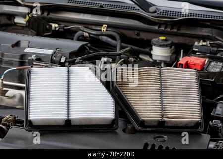 New and old, dirty air filter side by side on vehicle engine. Automotive repair, maintenance, service and fuel mileage concept Stock Photo