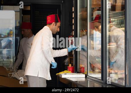 Istanbul, Turkey - September 17, 2023: A cook wearing an Ottoman fez in a restaurant serving traditional Ottoman dishes. Stock Photo