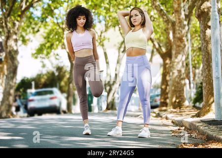 Friends, fitness and run with women and stretch in street for health, wellness or exercise with motivation. Runner or people with race, competition or Stock Photo