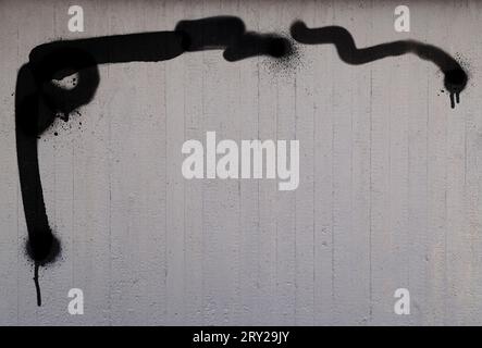 Front view of gray concrete wall with black spray painted lines and shapes. High resolution full frame abstract textured background with copy space. Stock Photo