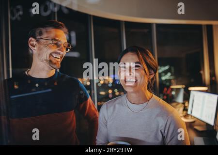 Tow business professionals and analysts brainstorm and plan for success in a nighttime meeting. business team collaborating, sharing ideas and working Stock Photo