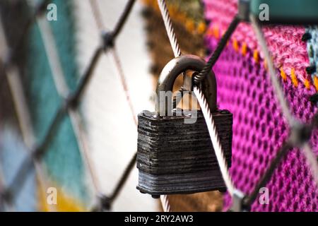 Rusty padlocks attached to the metal railing of a bridge, tradition of padlocks, symbol of eternal love Stock Photo