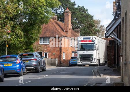Beaulieu village in the New Forest, Hampshire, England, UK. A large lorry trying to manoeuvre past a car on the narrow road Stock Photo