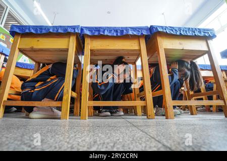 Luannan County, China - May 9, 2023: Elementary school students are conducting earthquake prevention emergency drills in a school. Stock Photo