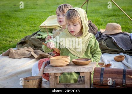 2 young Viking boys taste the food whilst celebrating 1100 years of the ancient “cyty” of Thelwall Stock Photo