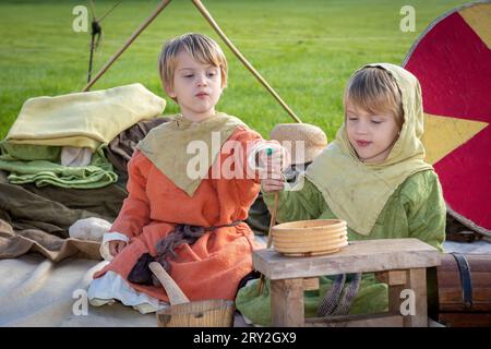 2 young Viking boys taste the food whilst celebrating 1100 years of the ancient “cyty” of Thelwall Stock Photo