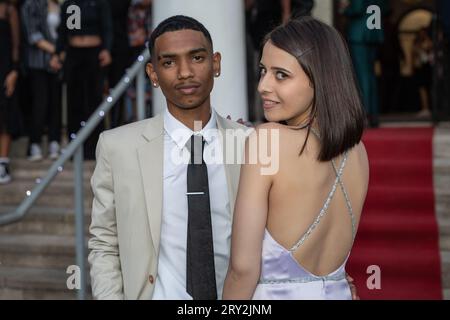In a close-up prom shot, a multiracial couple exudes allure as she looks over her shoulder, revealing the sparkly straps of her stunning dress Stock Photo
