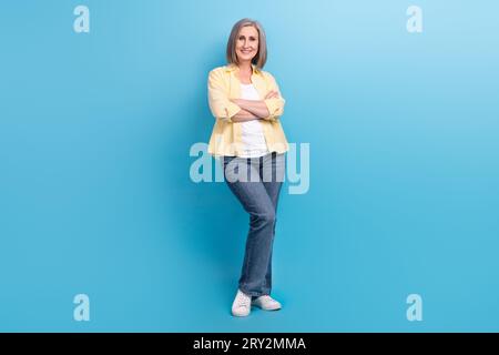 Full size photo of positive nice aged person good mood crossed arms posing isolated on blue color background Stock Photo