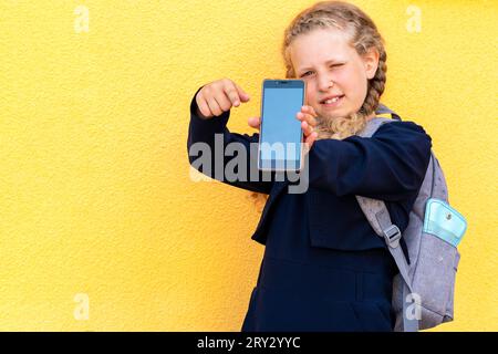 girl holds a smartphone. Concept use of gadgets by children, online training, online learning, online education. problem using tablets and gadgets . g Stock Photo