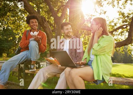 Confident smiling university students chatting together while taking rest Stock Photo