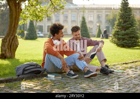 Two young fellow students talking together discussing ideas Stock Photo