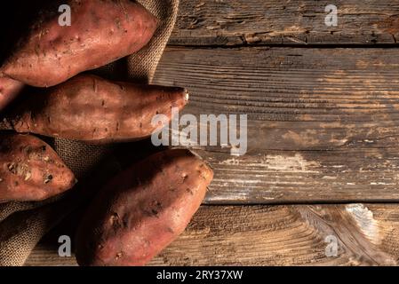 Sweet potatoes on rustic wooden table with copy space Stock Photo