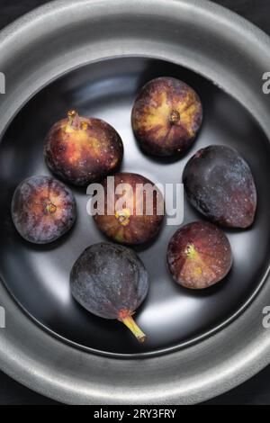 Top view of a black plate filled with fresh, ripe figs. Stock Photo