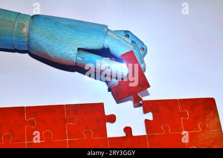 Close-up Of Robot And Human Hand Holding Red Jigsaw Puzzle , Digital transformation, AI, artificial intelligence technology, machine learning. Stock Photo
