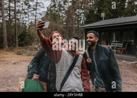 Happy friends taking selfie with mobile phone in yard Stock Photo