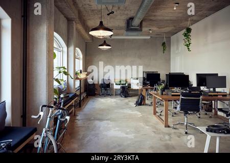 Computers on desks with chairs in office Stock Photo