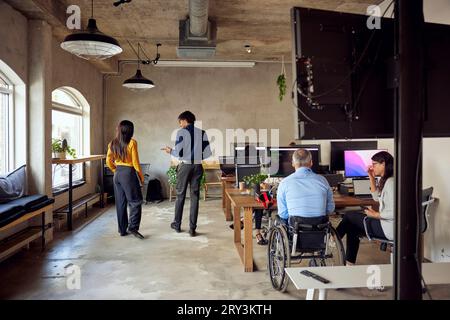 Colleagues discussing while working together at creative office Stock Photo
