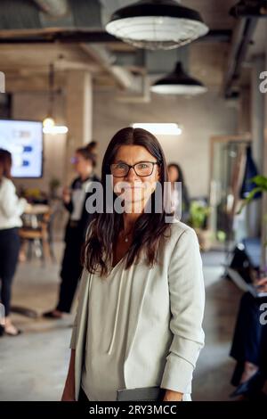 Portrait of businesswoman with long brown hair at creative office Stock Photo