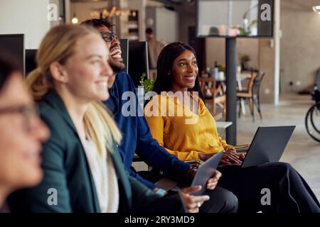 Happy multiracial business professionals sitting together at office Stock Photo