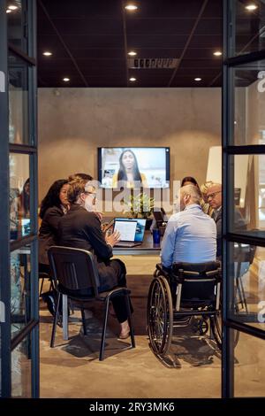 Businessmen and businesswomen discussing during video conference in board room at office Stock Photo