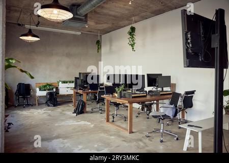 Computers on desks with chairs in office Stock Photo