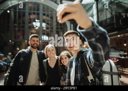 Happy boy taking selfie with family at station Stock Photo