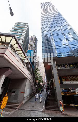 Hong Kong - July 15, 2017: Vertical street view of Hong Kong central district, wide angle photo with people walking the city Stock Photo