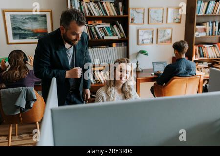 Smiling young female student with professor in library Stock Photo