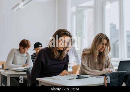 Young female students studying at desk in classroom Stock Photo