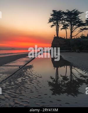 Red sky dawn reflections on Burrow Beach caused by saharan dust in the air Stock Photo