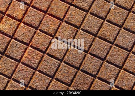 Rusty metal surface with a square grid pattern, industrial background texture. Stock Photo