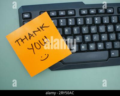 Top view of words thank you written on sticky note on keyboard Stock Photo