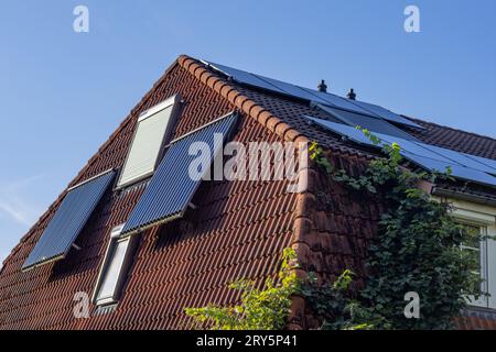 photovoltaics and tube collectors on a hipped roof Stock Photo