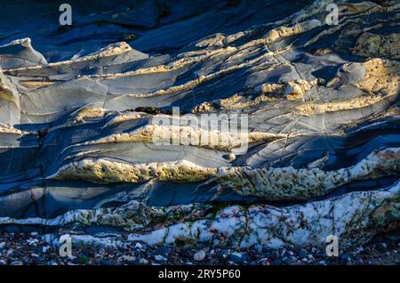 close-up of multi-coloured formation caused by geological striations in the rock on the beach at Groomsport County Down Stock Photo