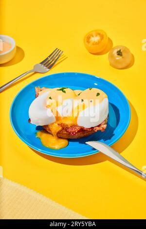 Poached eggs and bacon on toasted bun on plate over yellow background. Concept of breakfast, food. Pop art Stock Photo