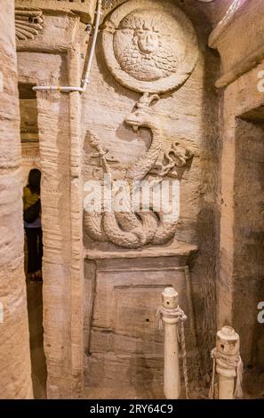 Kom el Shogafa necropolis, main tomb, second portico : Agathodaemon snake, holding caducaeus and Thyrsos scepters,  and Medusa head. Stock Photo