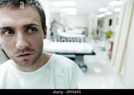 A portrait of a young man sitting in a hospital room. Stock Photo