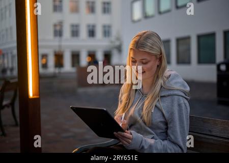 Positive young female illustrator drawing sketch on tablet Stock Photo