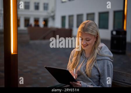 Smiling female artist drawing sketch on tablet with stylus Stock Photo