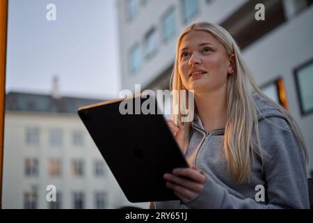 Happy woman holding tablet PC in city Stock Photo