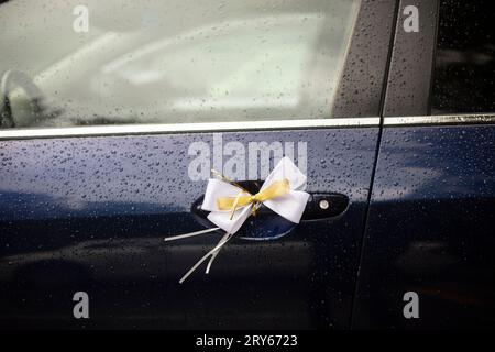 Cloth bow on car door. Decoration of transport for wedding. Stock Photo
