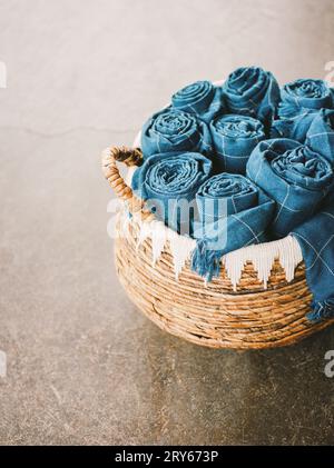 Rustic wicker basket with rolled blue blankets Stock Photo