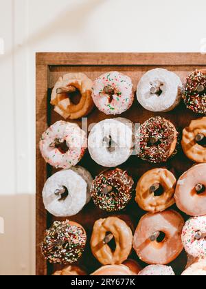 Wooden donut display with assorted donuts on pegs Stock Photo