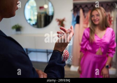 Woman trying on new gown in presence of fashion designer Stock Photo