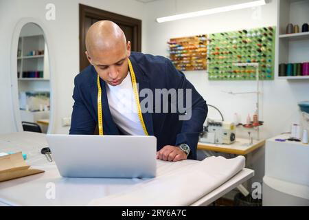 Focused African American clothier using his computer in workplace Stock Photo