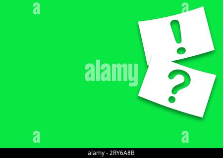 White pieces of paper with question marks and exclamation marks against a green background Stock Photo