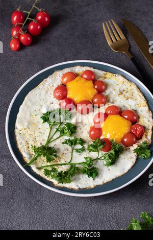 Scrambled eggs with cherry tomatoes in the shape of a flower, children's breakfast idea Stock Photo