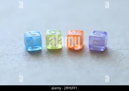 macro shot of colorful beads spelling the word love on a light background Stock Photo